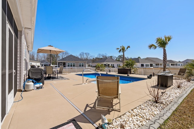 view of swimming pool with outdoor dining space, a patio, a fenced in pool, a fenced backyard, and a residential view