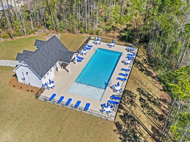 pool with a patio area, a yard, and fence