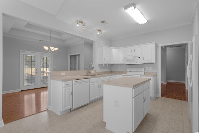 kitchen featuring white appliances, light floors, light countertops, and a sink