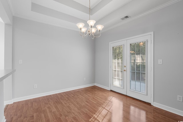 spare room featuring french doors, a tray ceiling, and wood finished floors