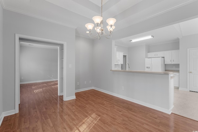 unfurnished dining area featuring baseboards, light wood-type flooring, an inviting chandelier, and ornamental molding