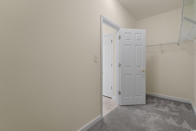 walk in closet featuring light carpet