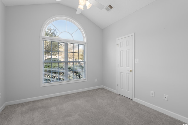 unfurnished room featuring baseboards, visible vents, carpet floors, lofted ceiling, and ceiling fan