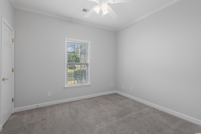 carpeted spare room with baseboards, ceiling fan, and crown molding