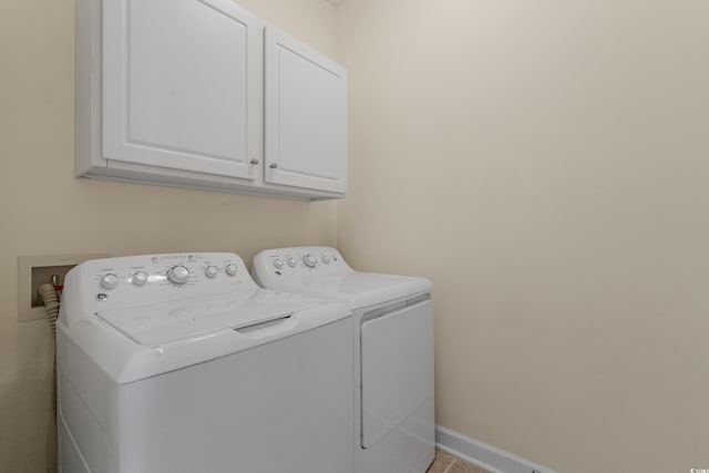 laundry room with washer and clothes dryer, cabinet space, and baseboards