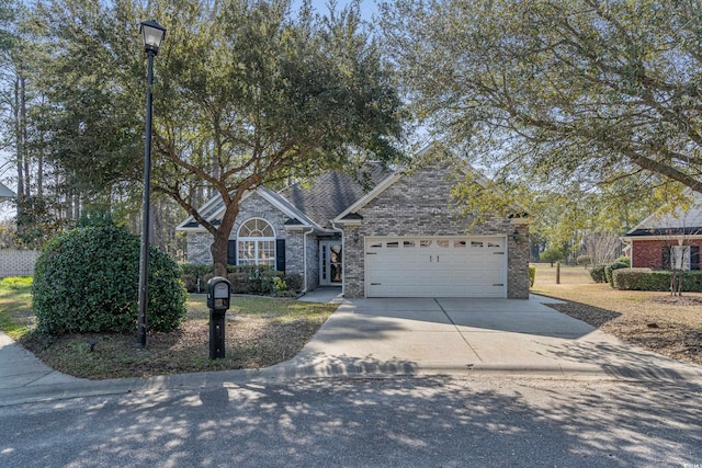 view of front of property with brick siding, driveway, and a garage