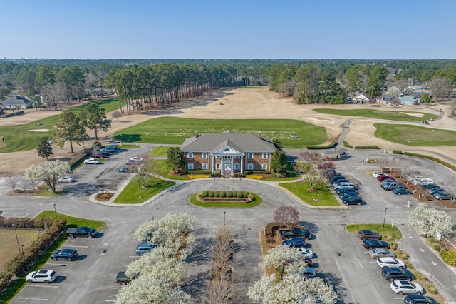 drone / aerial view featuring a view of trees and golf course view