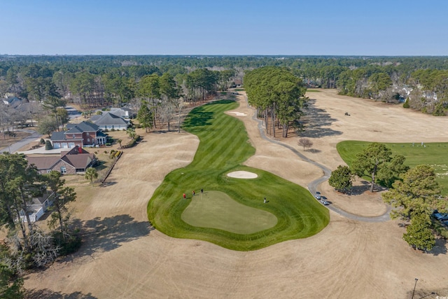 birds eye view of property with golf course view and a view of trees