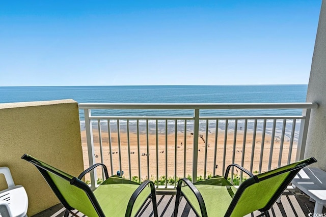 balcony featuring a water view and a beach view