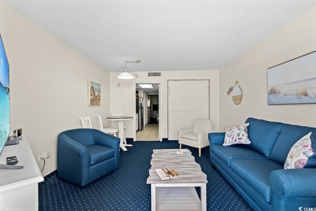 carpeted living area featuring visible vents and a textured ceiling