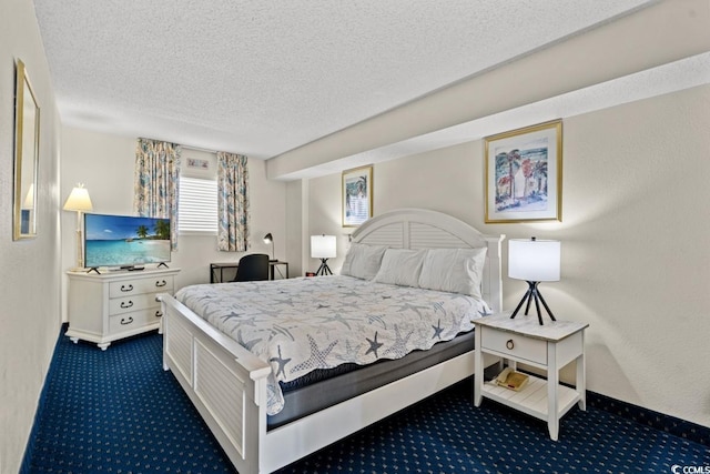 bedroom featuring a textured ceiling, baseboards, and dark colored carpet