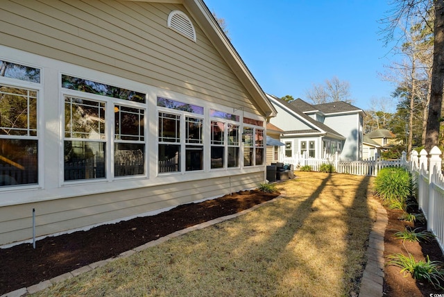 exterior space featuring a lawn and fence