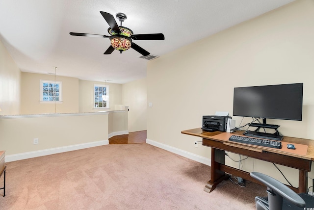 office area featuring baseboards, carpet floors, visible vents, and ceiling fan