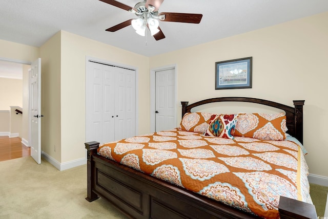 bedroom with a ceiling fan, light colored carpet, a closet, and baseboards