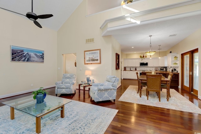 living area featuring dark wood finished floors, baseboards, visible vents, and ceiling fan