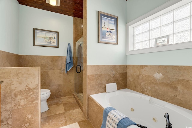 full bath with a shower stall, a jetted tub, toilet, and tile walls