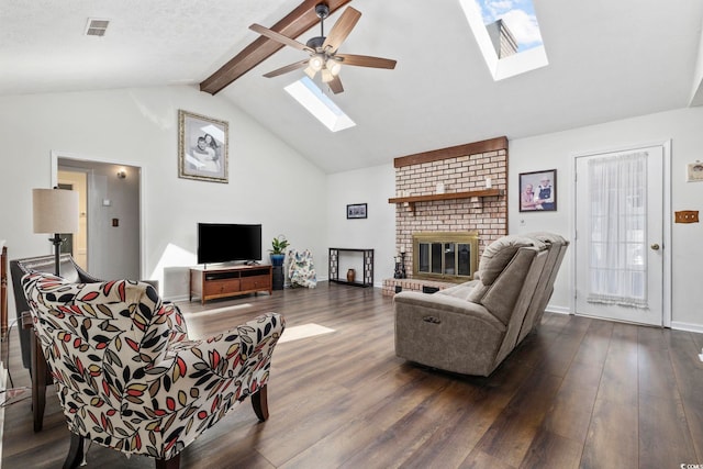 living area with visible vents, dark wood-type flooring, a ceiling fan, a skylight, and a brick fireplace