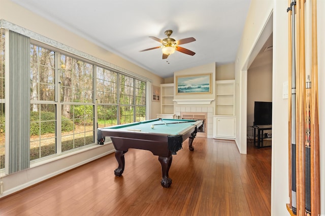 game room featuring ceiling fan, pool table, hardwood / wood-style flooring, vaulted ceiling, and a tiled fireplace