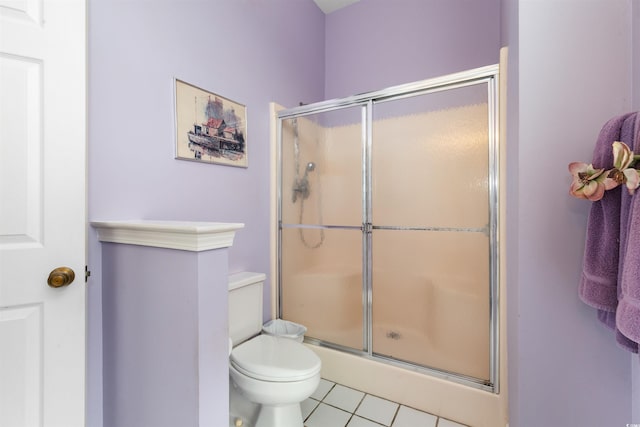 bathroom featuring toilet, tile patterned floors, and an enclosed shower