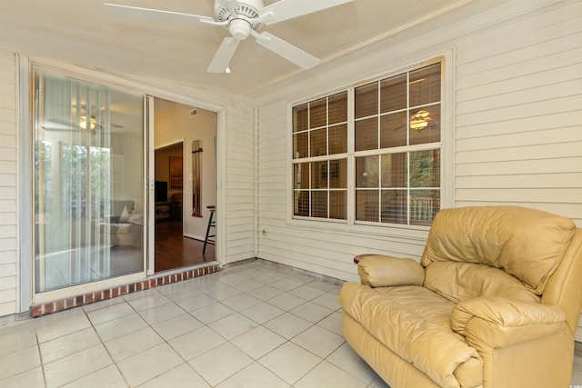 unfurnished sunroom featuring a ceiling fan