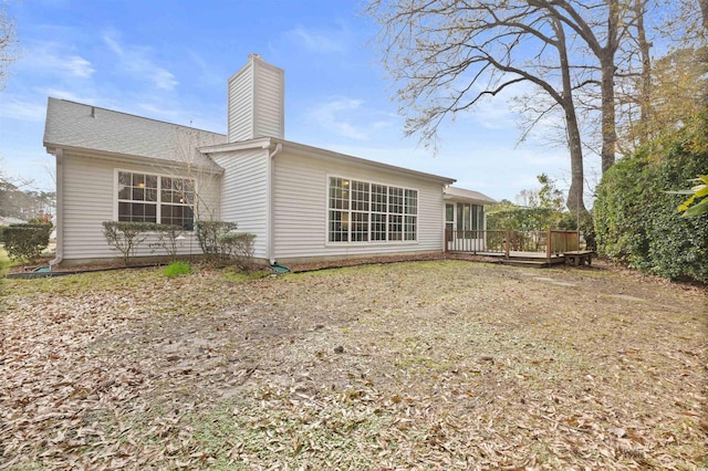 rear view of house with a deck and a chimney