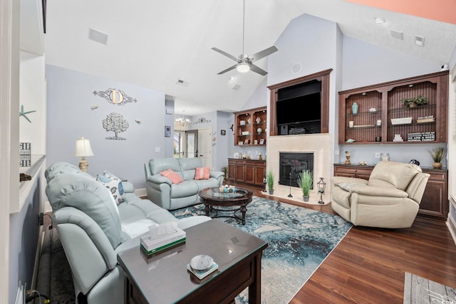 living area featuring visible vents, ceiling fan, wood finished floors, a glass covered fireplace, and high vaulted ceiling