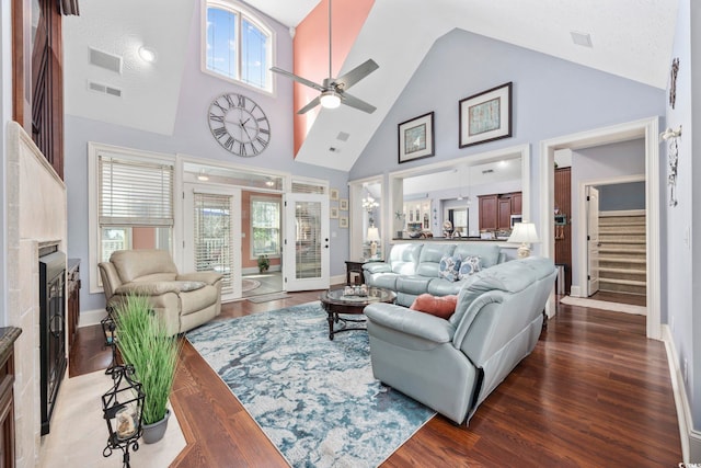 living room featuring visible vents, ceiling fan, a fireplace with flush hearth, stairs, and wood finished floors