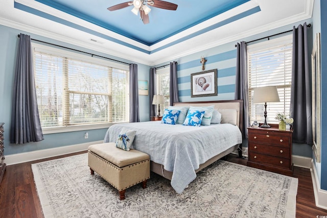 bedroom with baseboards, a raised ceiling, and wood finished floors