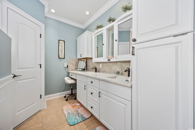 bathroom featuring a sink, backsplash, double vanity, and crown molding