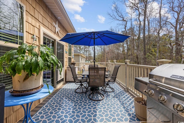 wooden deck with outdoor dining area and a grill