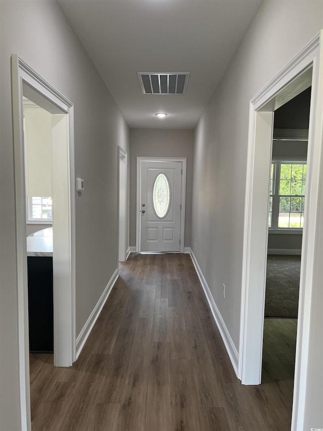 doorway featuring visible vents, dark wood finished floors, baseboards, and a wealth of natural light