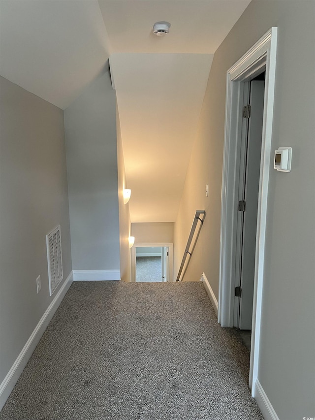 corridor featuring baseboards, an upstairs landing, carpet, and visible vents