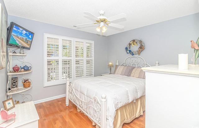 bedroom with visible vents, light wood-style flooring, baseboards, and ceiling fan