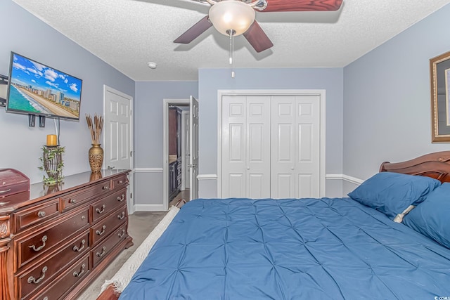 bedroom featuring a closet, connected bathroom, a textured ceiling, and ceiling fan