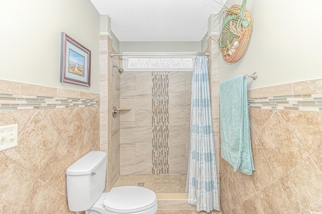 bathroom featuring tile walls, toilet, a tile shower, and a textured ceiling