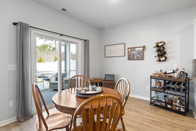 dining area with light wood-type flooring and baseboards