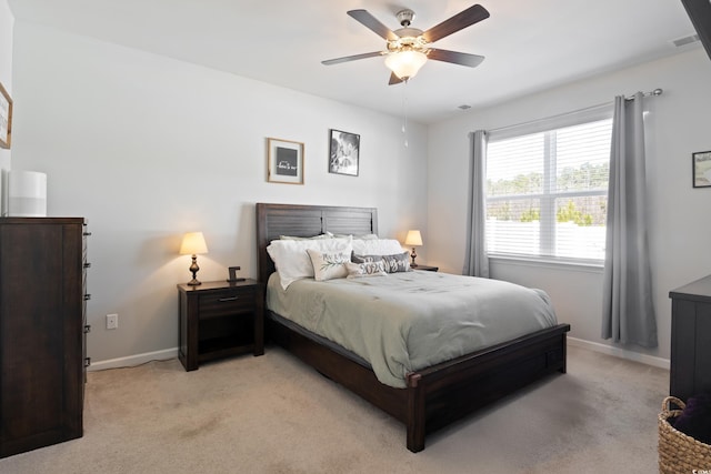 bedroom featuring light carpet, baseboards, and ceiling fan
