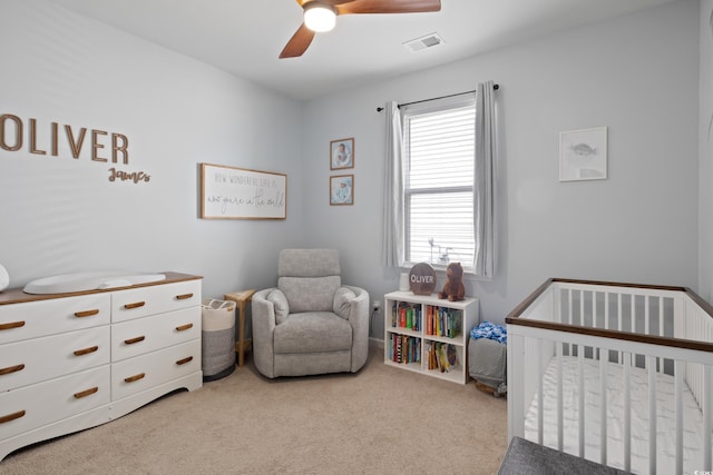 carpeted bedroom with a nursery area, multiple windows, and ceiling fan