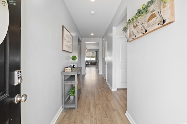 corridor featuring light wood-style floors, baseboards, and recessed lighting