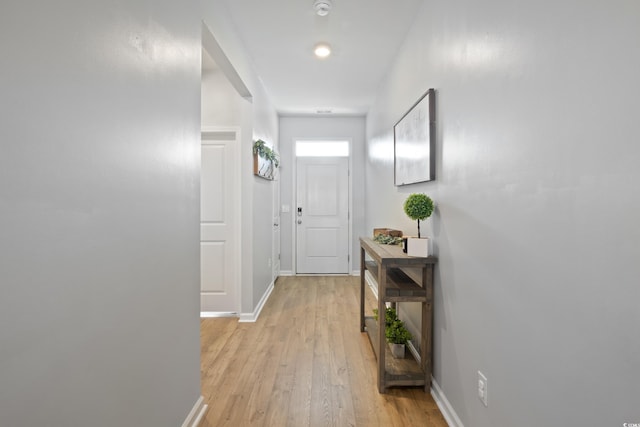 doorway to outside featuring light wood finished floors and baseboards