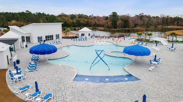 community pool with a water view and a view of trees
