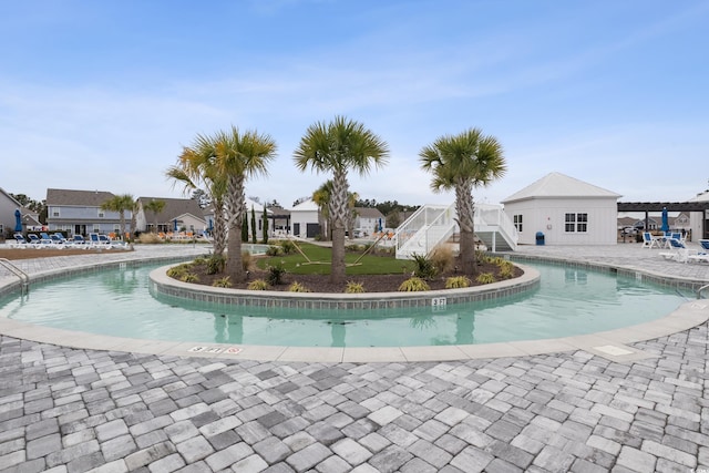 community pool with a residential view, stairs, and a patio area