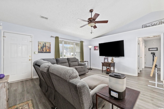 living room with ceiling fan, visible vents, wood finished floors, lofted ceiling, and baseboards