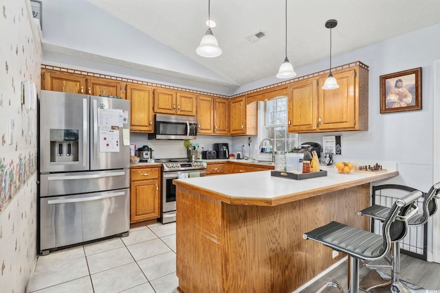 kitchen with a peninsula, visible vents, brown cabinets, lofted ceiling, and stainless steel appliances
