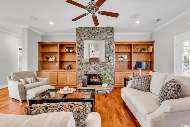 living room featuring a ceiling fan, a stone fireplace, visible vents, recessed lighting, and light wood-style flooring