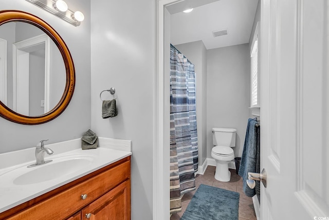 bathroom with tile patterned floors, vanity, toilet, and visible vents