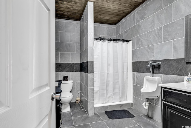 full bathroom with a shower with curtain, tile walls, tile patterned flooring, vanity, and toilet