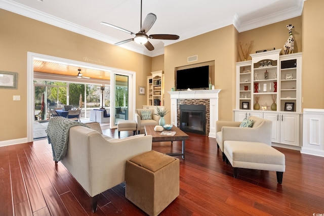 living room featuring visible vents, dark wood-type flooring, ceiling fan, crown molding, and a fireplace