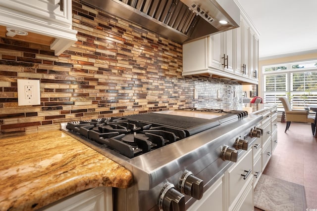 kitchen with custom range hood, white cabinets, light countertops, decorative backsplash, and stainless steel gas cooktop