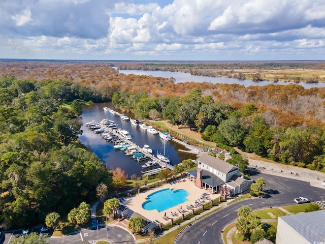 birds eye view of property with a water view and a wooded view